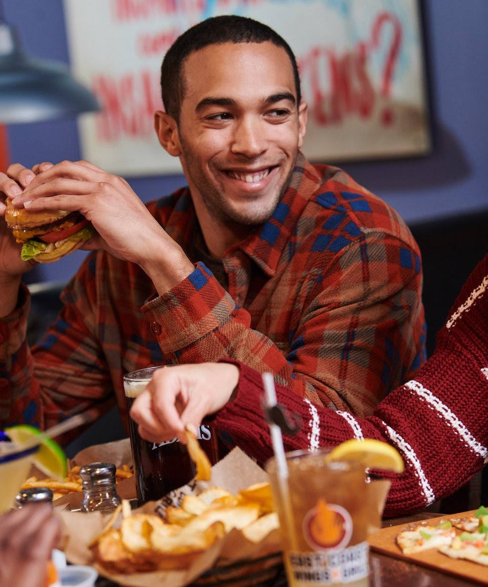 Smiling man eating hamburger Lifestyle Photography from K2 Productions